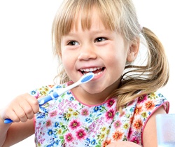 little girl with pigtails brushing teeth 