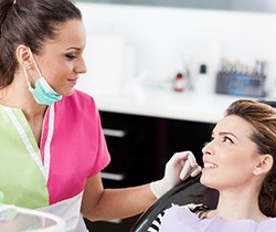 Patient and dental assistant smiling at each other