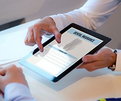 Patient reviewing dental insurance form on tablet