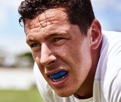 Man with blue mouthguard on field