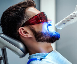 man smiling during in-office teeth whitening treatment