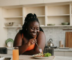 Woman smiling while eating lunch at home