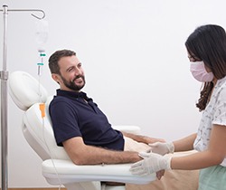 a young man receiving IV sedation from a dental assistant